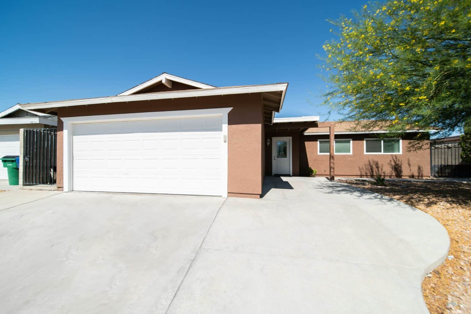 Orange colored home with a large driveway.